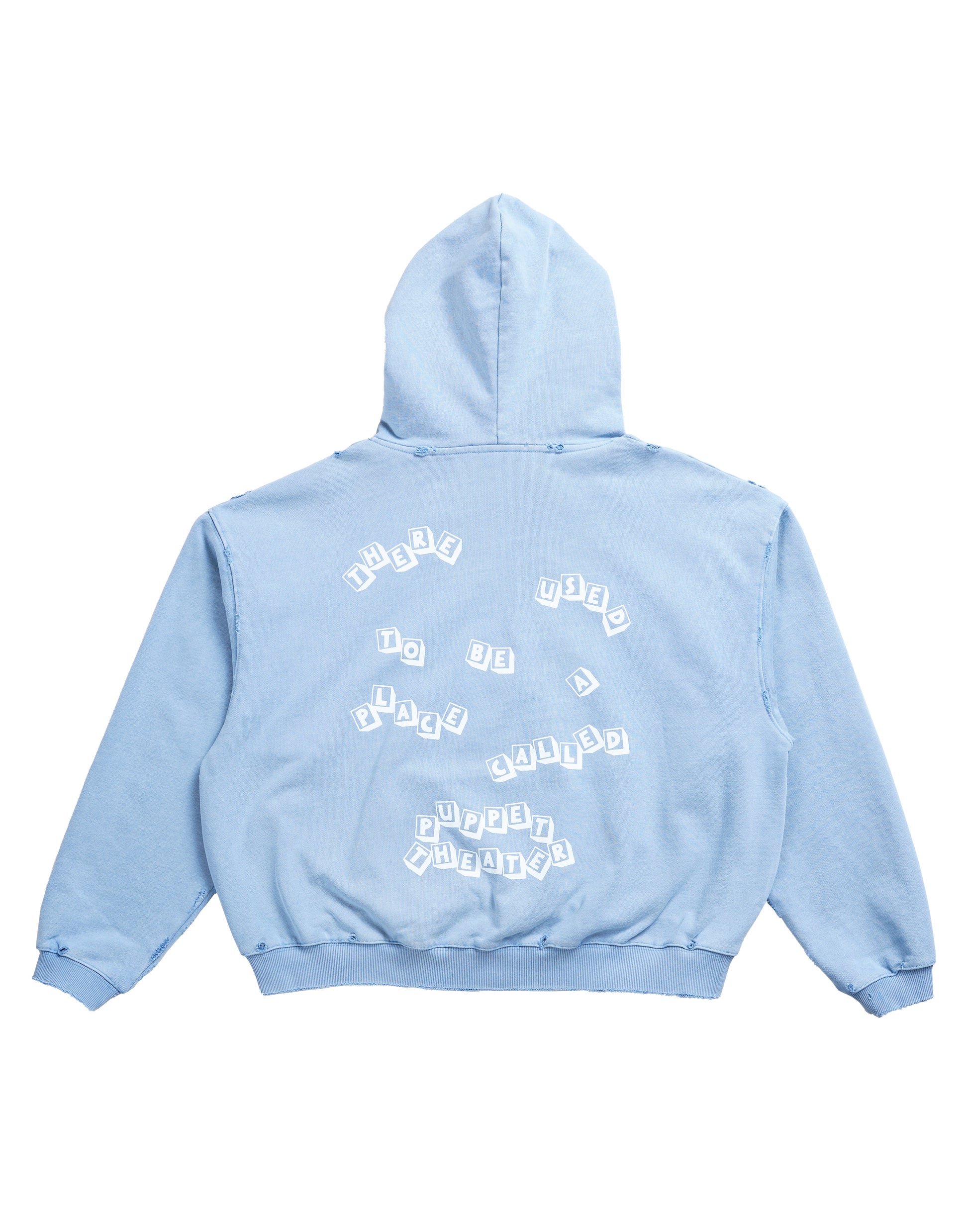 Flat lay back of the Reminiscence Block Logo Hoodie in pastel-faded baby blue. The design features the phrase ‘There used to be a place called Puppet Theater’ in toy block lettering — a tribute to the original Denver Puppet Theater. Crafted in 100% cotton French terry with a vintage wash and hand-finished distressing for a worn-in luxury streetwear look.