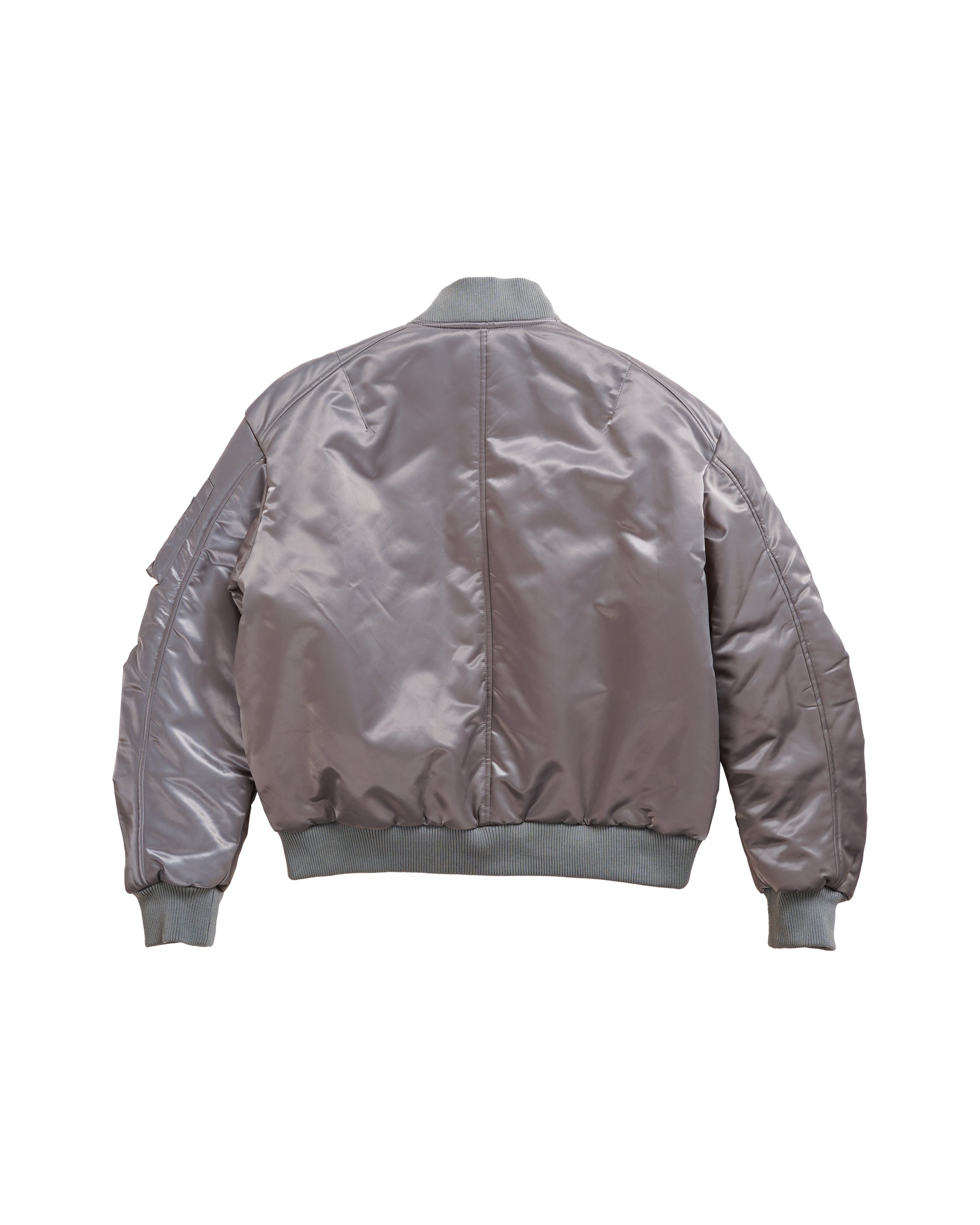 Flat lay back of the Ruched Bomber — heritage military bomber silhouette in technical nylon with cocoon-like shape and subtle fashion-forward drape.