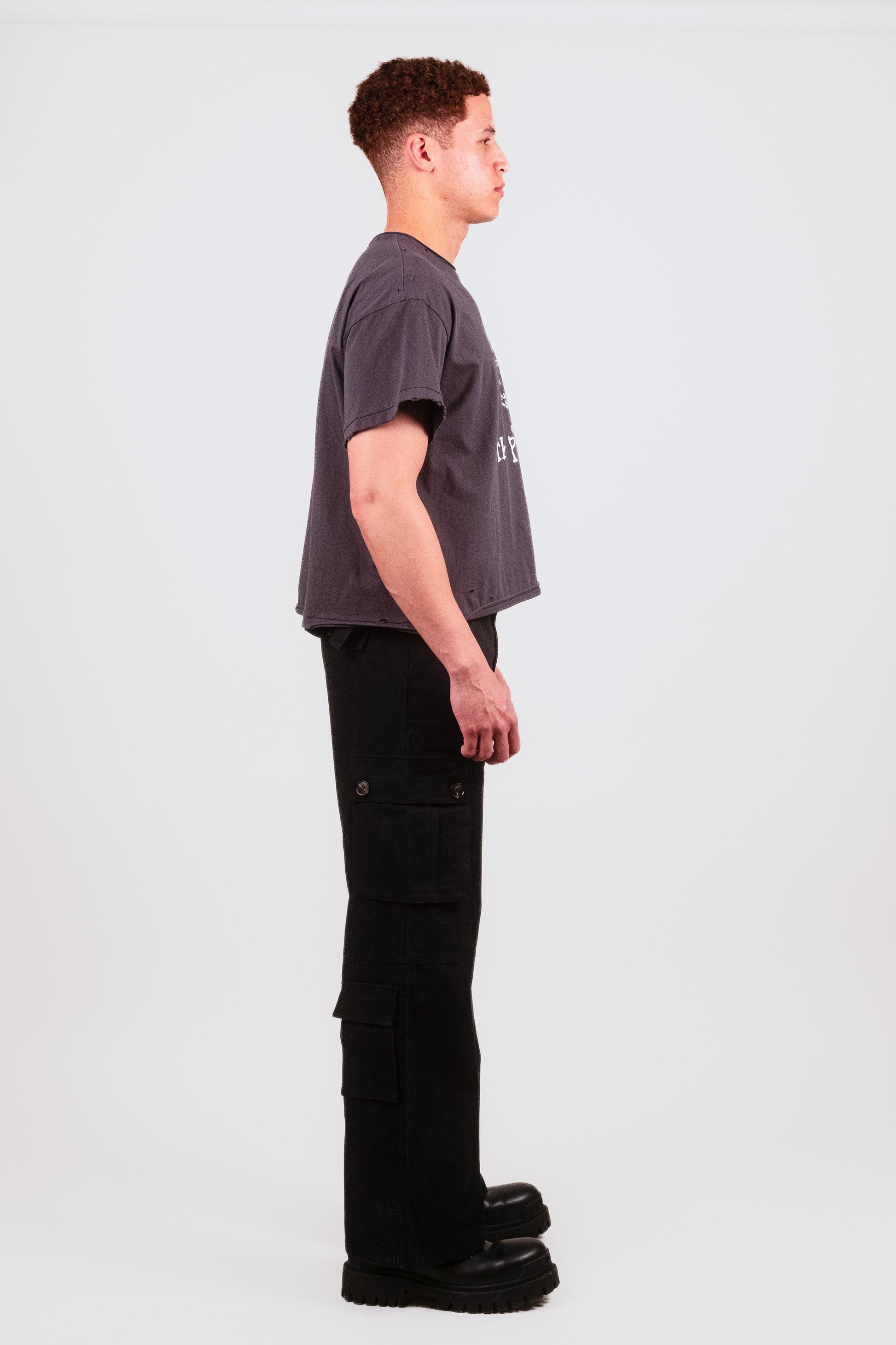 Male model in alternate profile view wearing the Puppets Punk Tee — hand-distressed designer t-shirt with bold punk band print and elevated cut.