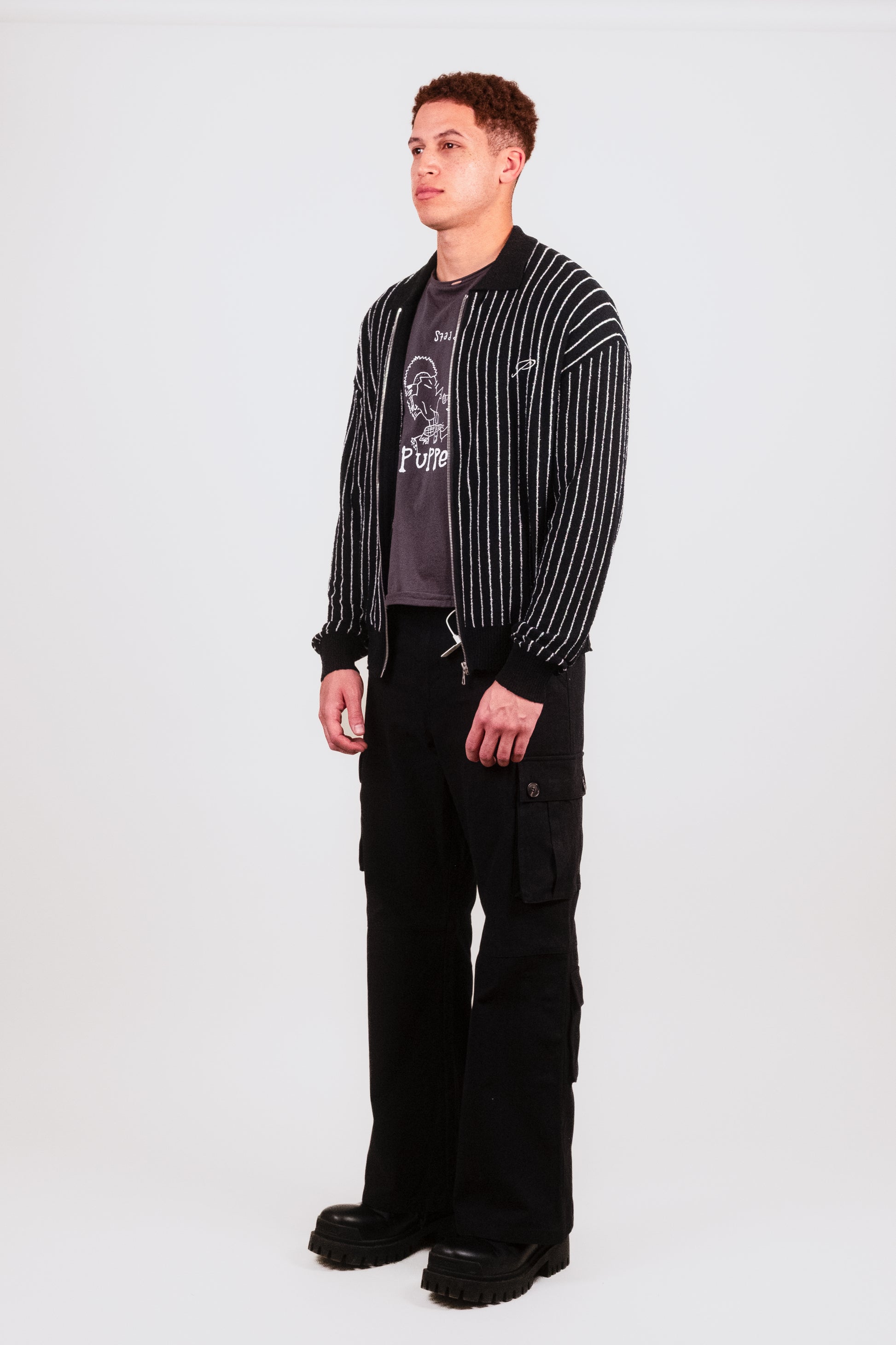 Nate in a 1/4 angle shot wearing the Six Pocket Flare Cargo, emphasizing functional cargo pockets, premium button fastenings, and the herringbone texture of the heavyweight twill.