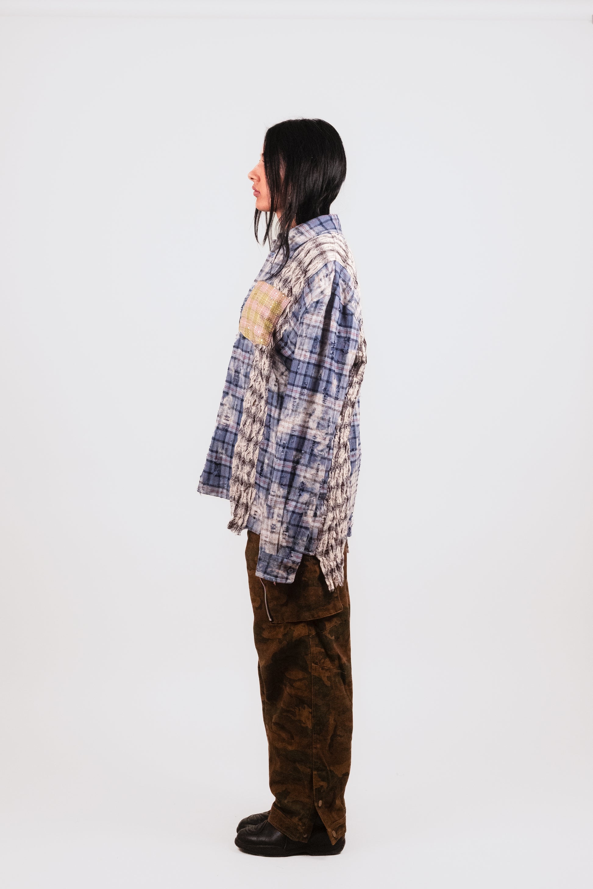 Female model profile in Fever Dream Flannel — layered flannel shirt with dreamy oversized fit, glittered vintage pocket, and distressed blue plaid for a grunge-luxe streetwear vibe.