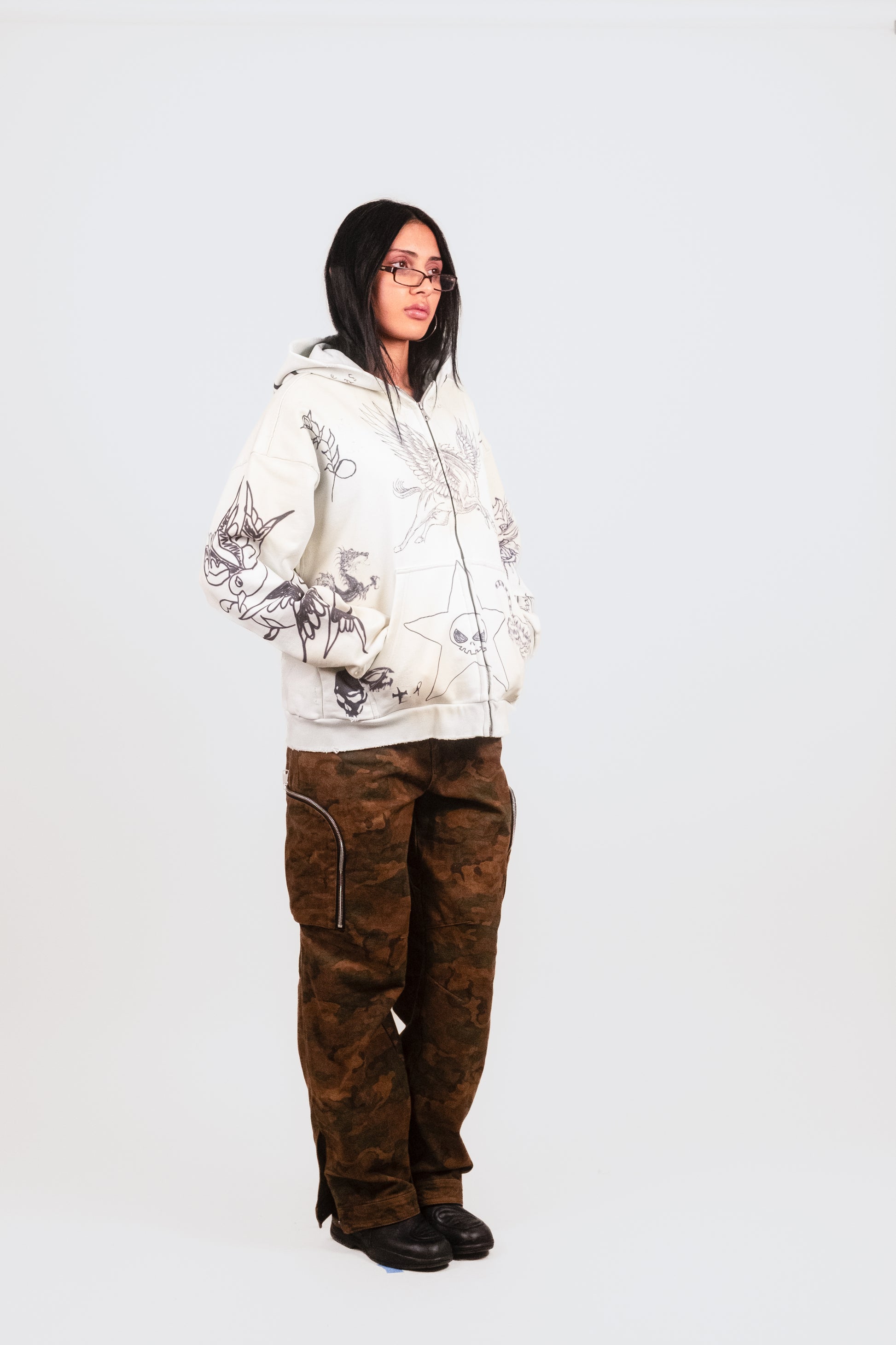 Female model alt 1/4 angle in Objector Cargo — designer camo pant with signature Puppet Theater shaping and utility detailing
