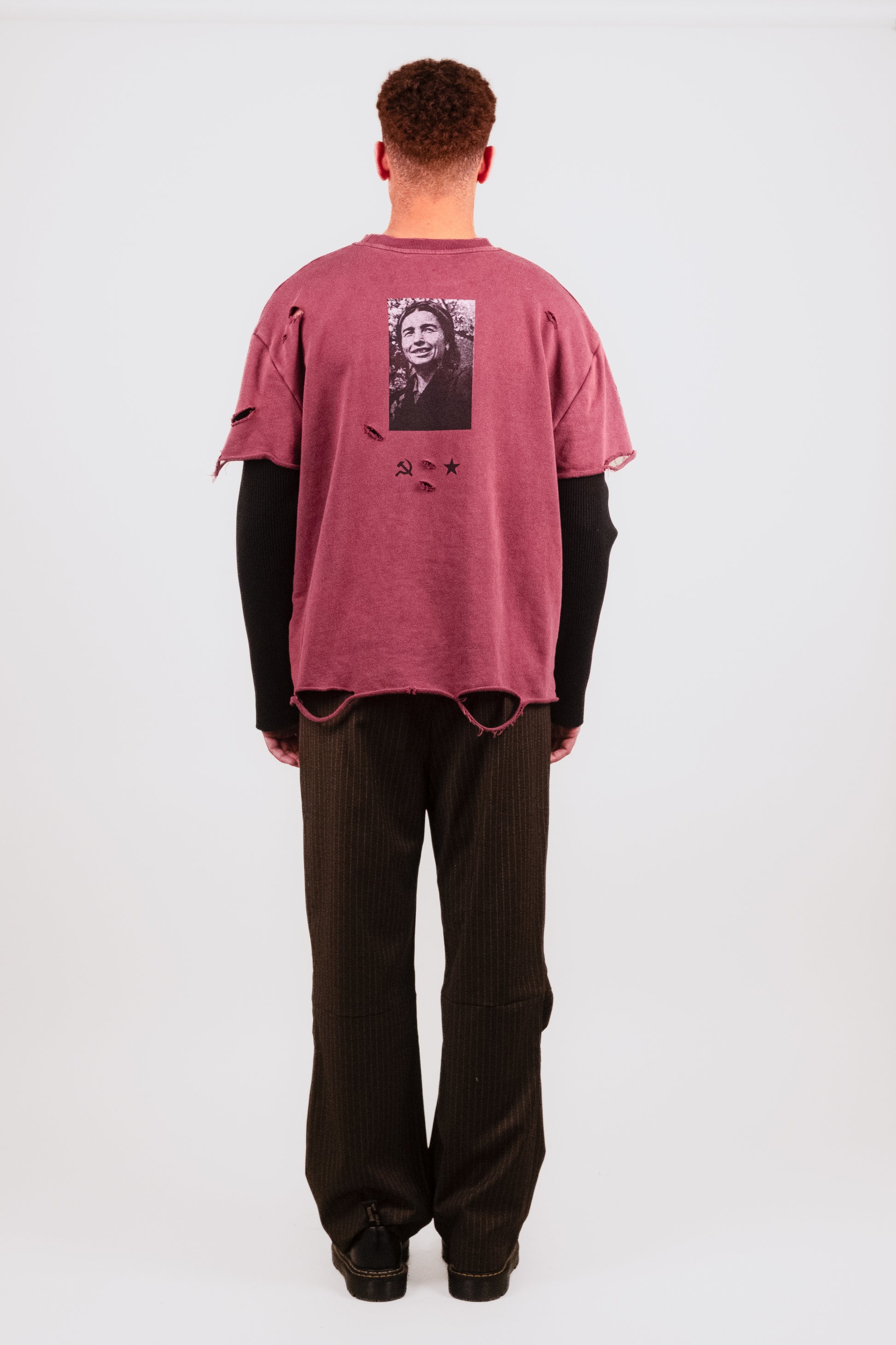Male model back view of Tucked Trouser — high-end pinstripe trouser with adjustable waist and signature Puppet Theater detailing