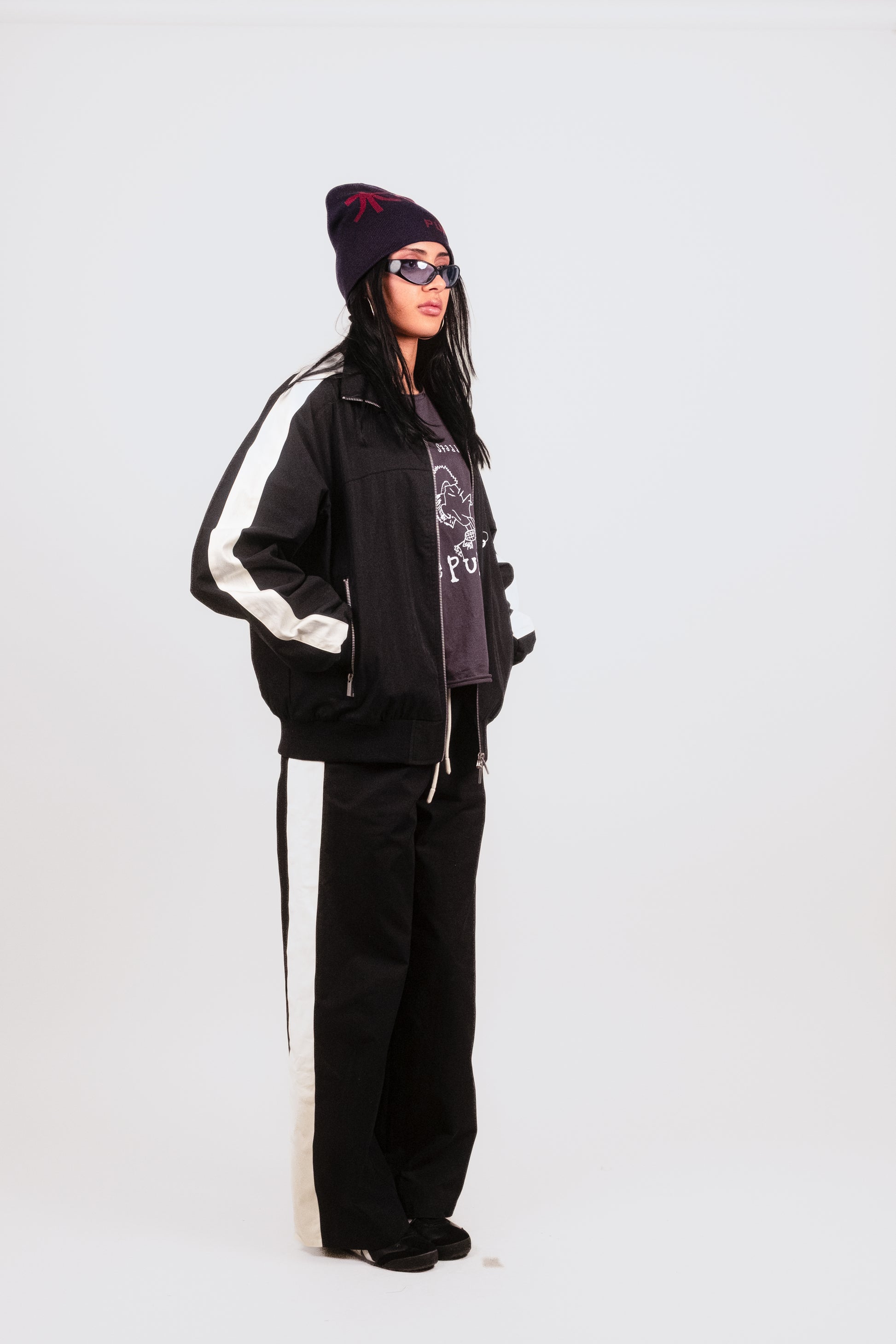 Alternate quarter angle of Anisa in the Sports Bottom — fashion-forward track pant silhouette in lightweight technical nylon with concealed side venting for modular styling.
