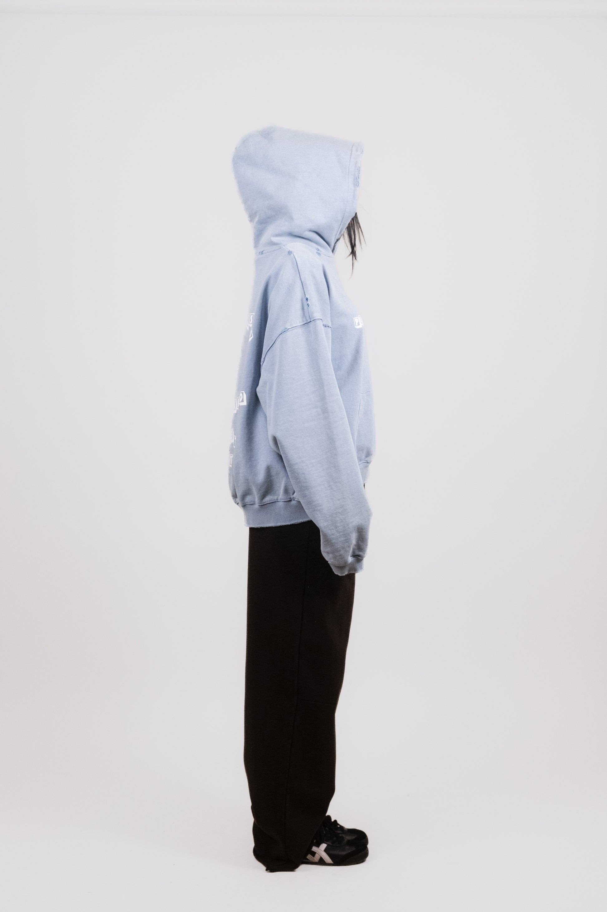 Alternate profile of Anisa in the Reminiscence Block Logo Hoodie — showcasing the piece’s elegant boxy drape, washed baby blue colorway, vintage-inspired construction, and nostalgic toy block graphics. A modern streetwear essential with luxury craftsmanship.
