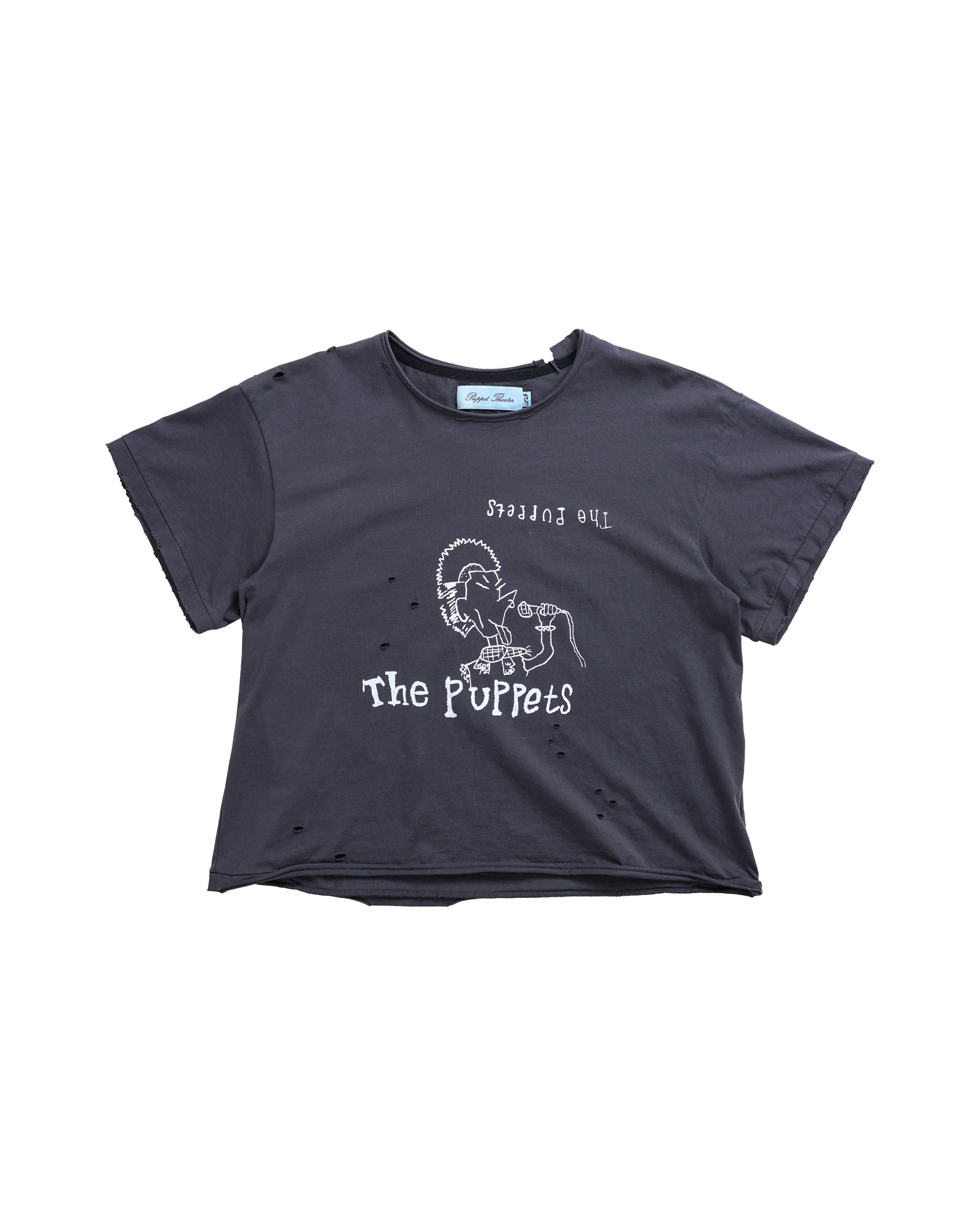 Flat lay of the Puppets Punk Tee — a distressed black cropped t-shirt with white punk-inspired band graphic of a mohawked singer. High-end streetwear silhouette with cap sleeves and raw vintage finish.